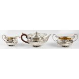 A matched silver three piece tea set, comprising a tea pot, milk jug and sugar bowl, of cherub and
