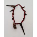 A 19th century African amulet witch doctor’s necklace with red glass beads,wood,horn and glass