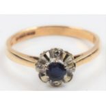 A hallmarked 9ct yellow gold sapphire and diamond flower design ring, set with a central round cut