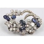 A sapphire and diamond cluster design brooch, set with round brilliant cut diamonds of various sizes