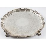 A Victorian silver salver, engraved with scroll pattern with central lion motif, raised on four