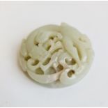 A pale green jade round pierced disk with spiral dragon. Approx 5cm.