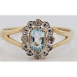 A hallmarked 9ct yellow gold blue topaz and diamond cluster ring, set with an oval blue topaz