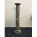 A grey and white marble canon form column stand