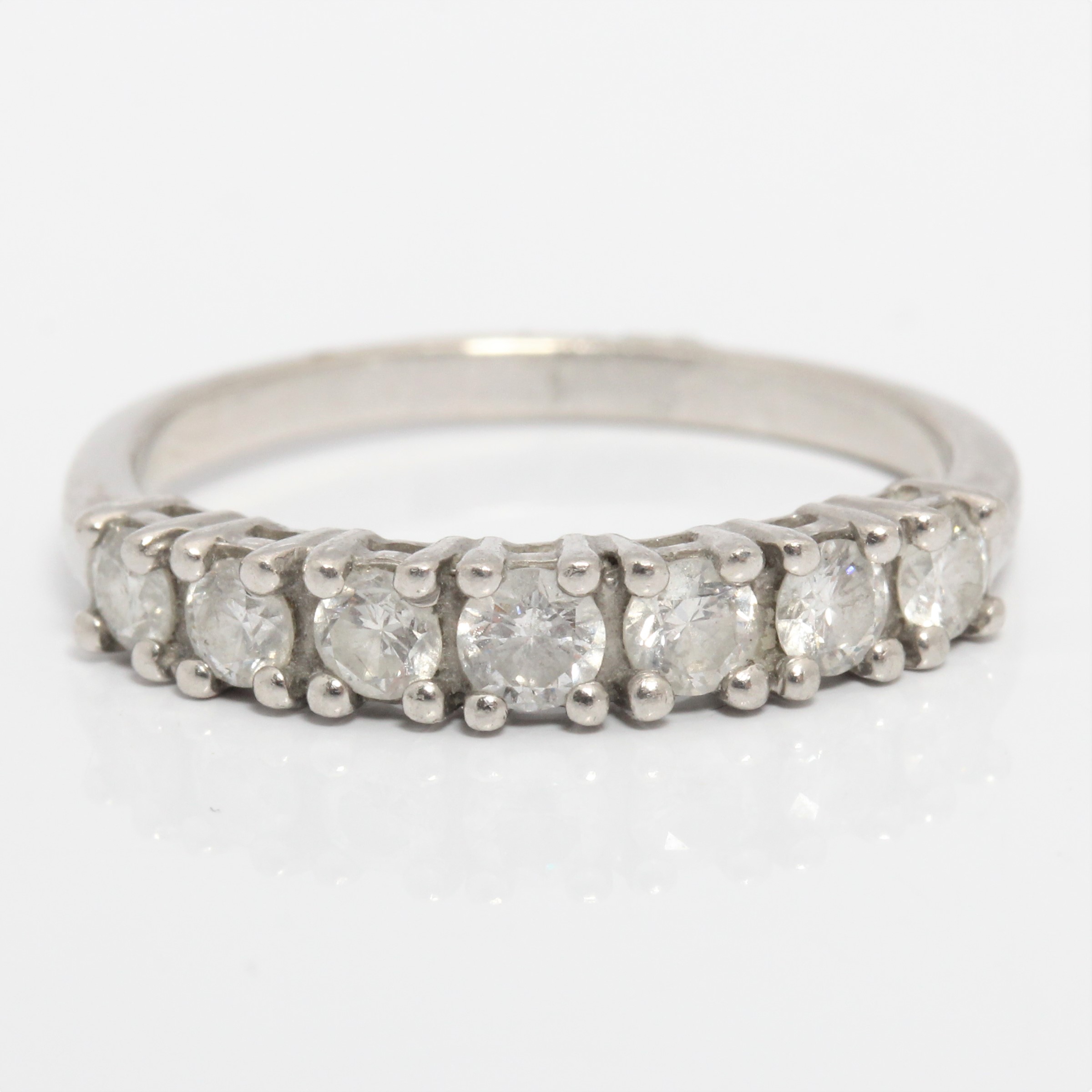 A seven stone diamond half eternity ring, set with seven round brilliant cut diamonds, total diamond