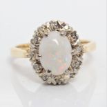 An opal and diamond cluster ring, set with an oval opal cabochon, measuring approx. 9x6mm,