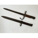 Two bayonets, one adapted with Arabic writing.