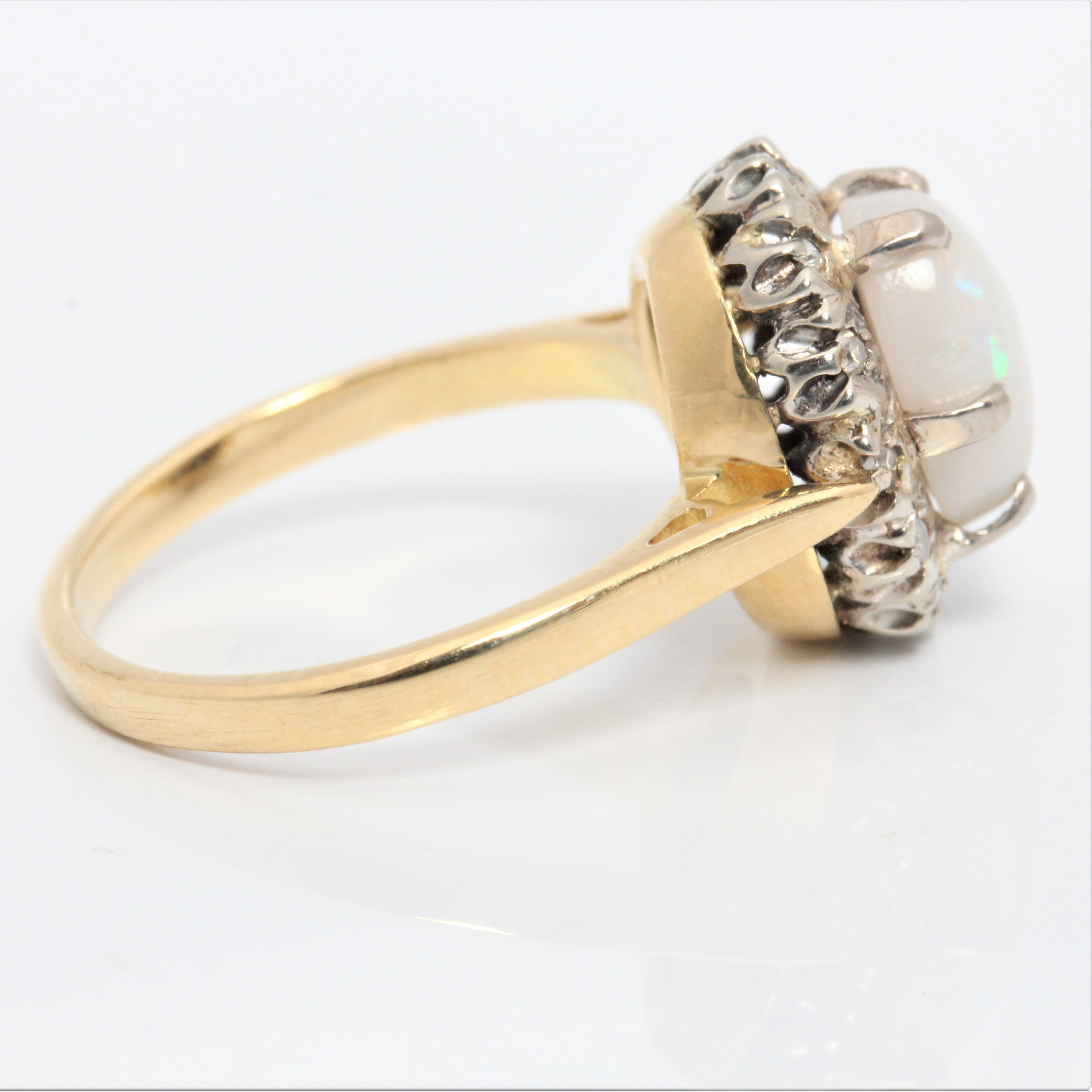 An opal and diamond cluster ring, set with an oval opal cabochon, measuring approx. 9x6mm, - Image 2 of 4
