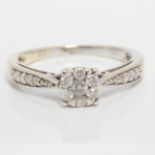 A diamond cluster ring, set with seven round brilliant cut diamonds in flower cluster, with