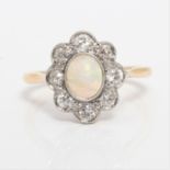 An opal and diamond cluster ring, set with an oval opal cabochon, measuring approx. 7x5mm,