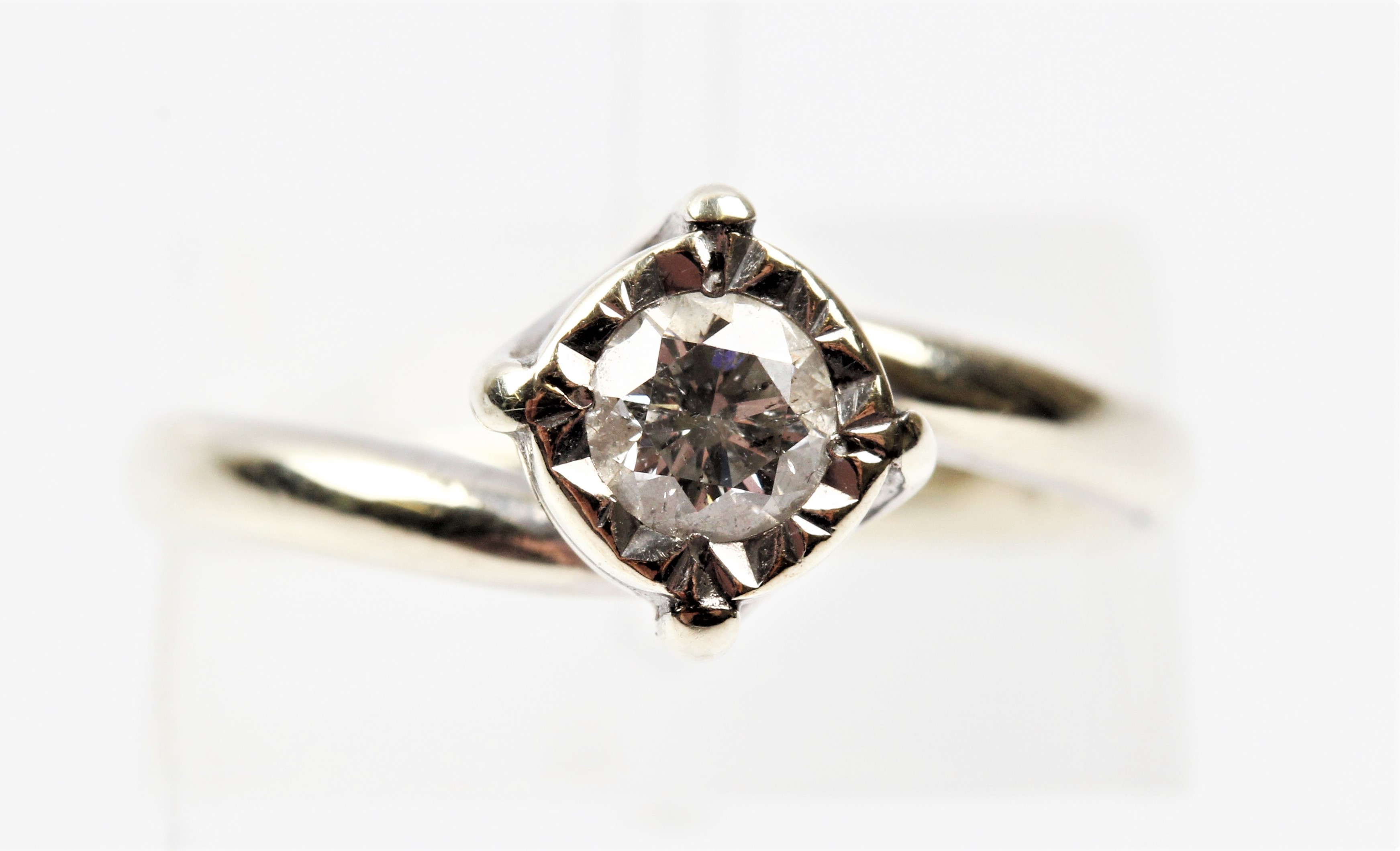 A hallmarked 9ct white gold diamond solitaire ring, illusion set with a round brilliant cut