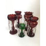 Four red, glass nineteenth century lustres with glass droppers and one green lustre