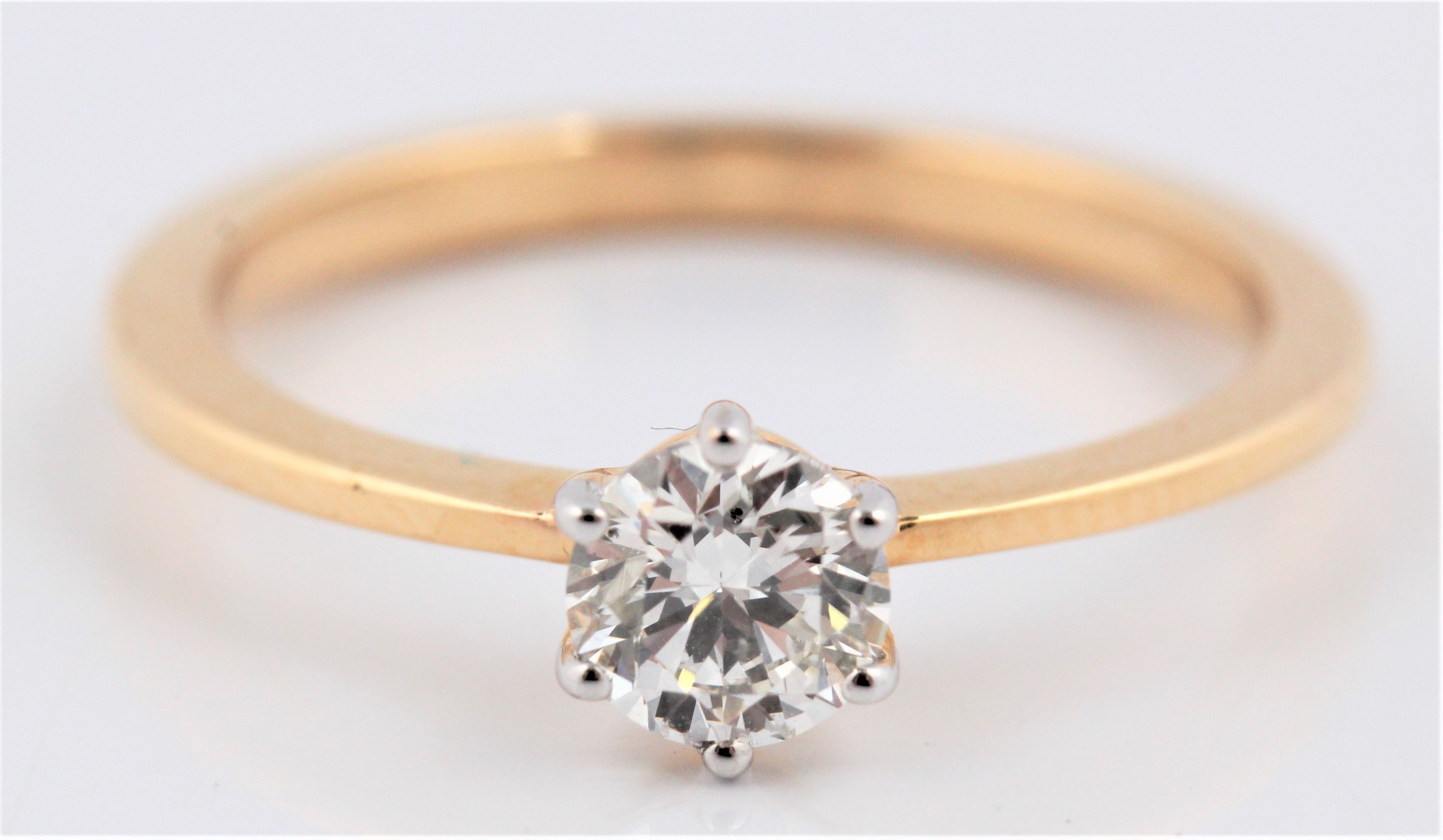 A hallmarked 18ct yellow gold diamond solitaire ring, set with a round brilliant cut diamond,