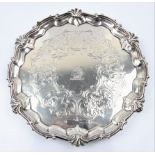 A Victorian silver salver, with scrolling rim and engraved with scrolls and floral design, raised on