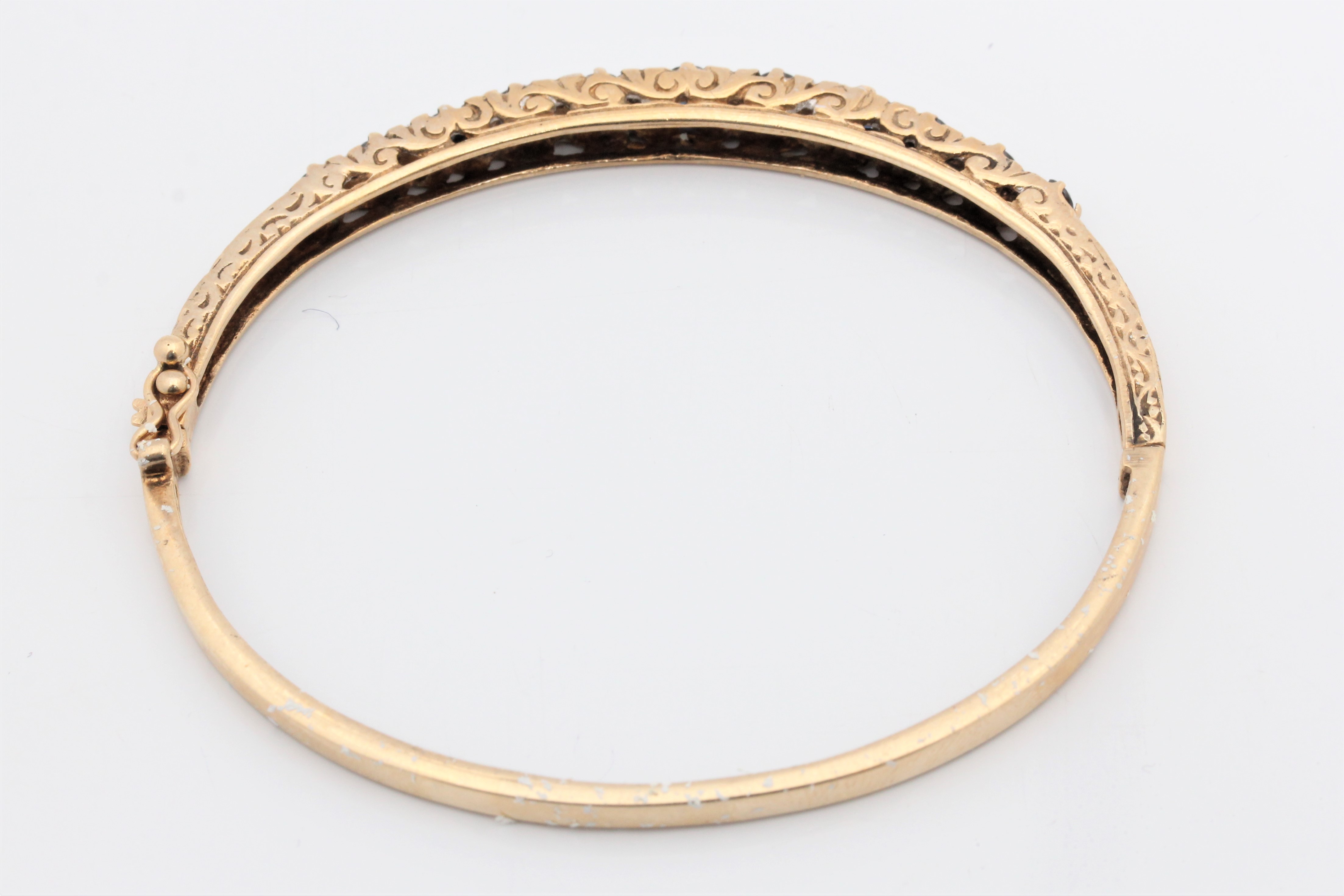 A hallmarked 9ct yellow gold sapphire and diamond hinged bangle, set with eleven graduated round cut - Image 2 of 3