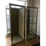 Two glass display cabinets with one key. Both with shelves,