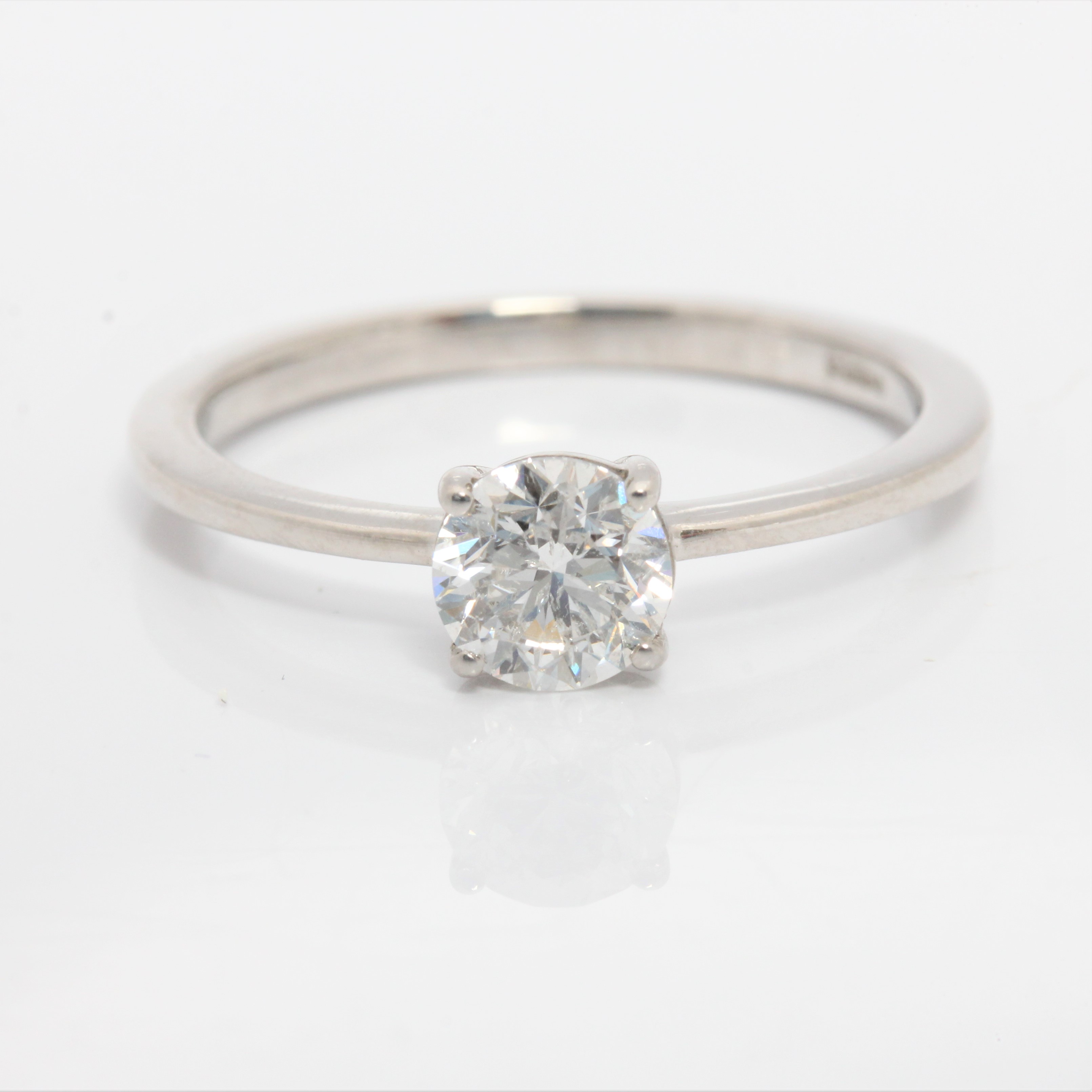 A hallmarked platinum diamond solitaire ring, set with a round brilliant cut diamond measuring