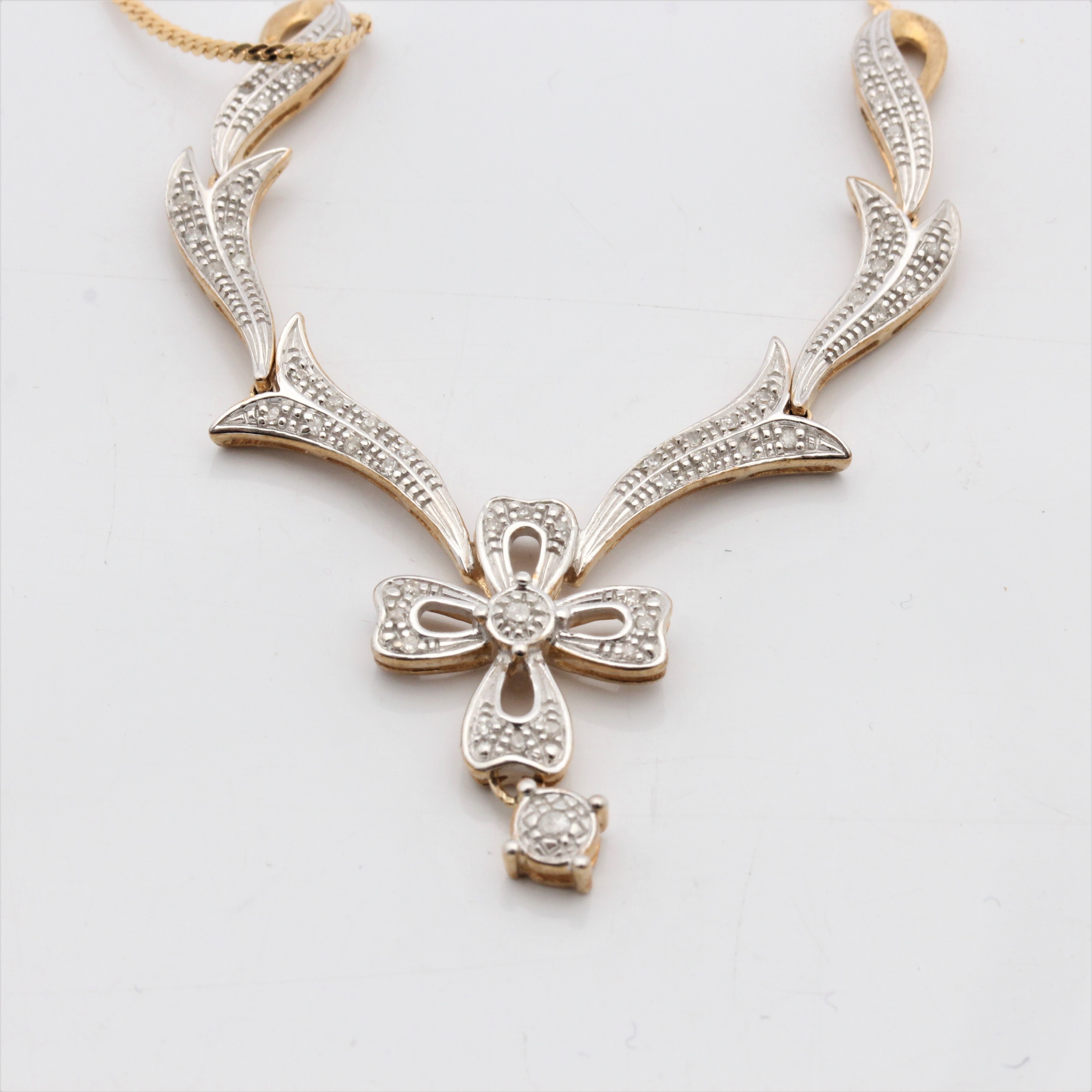 A diamond set necklet, the open metalwork floral and scroll leaf design set with diamond accents,