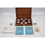 A wooden box of limited edition silver medallions of Queens of the British Isles. Plus a few loose