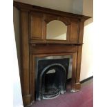 An early 20th Century solid oak, raised back mirrored and panel fire surround, fluted column sides