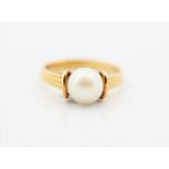 A pearl set ring, stamped 18ct, ring size L.