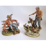 Two Capo Di' Monte figurines, one depicting a roughly dressed man on a park bench giving birds water