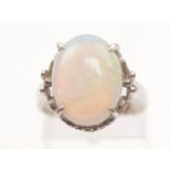 An opal dress ring, set with an oval opal cabochon measuring approx. 15x12mm, with scroll design