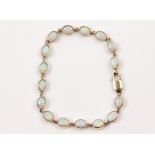 An opal bracelet, set with sixteen oval opal cabochons each bezel set as articulated links,