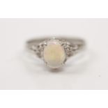 An opal and diamond ring, set with a central oval opal cabochon measuring approx. 8x6mm, flanked