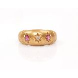 An early 20th Century hallmarked 18ct yellow gold ruby and diamond three stone ring, star set with a