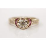 A diamond and ruby ring, set with a principal round brilliant cut diamond, measuring approx. 1ct,