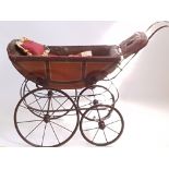 A cast iron Victorian pushchair with porcelain handle and leather interior.
