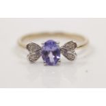A hallmarked 9ct yellow gold tanzanite and diamond ring, set with a central oval cut tanzanite, with