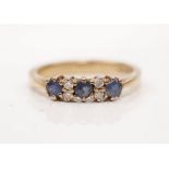 A hallmarked 9ct yellow gold sapphire and diamond ring, set with three round cut sapphires each