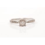 A hallmarked 9ct white gold diamond ring, set with a principal round brilliant cut diamond,