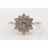 A tiered diamond cluster ring, set with round cut diamond accents, indistinctly marked, ring size