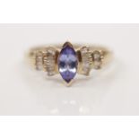 A hallmarked 9ct yellow gold tanzanite and diamond ring, set with a central marquise cut tanzanite