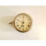 A round brass Smith ship’s clock with key.