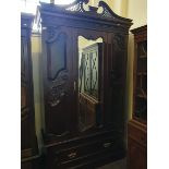 An edwardian single mirror door wardrobe with a pierced top.