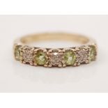 A peridot and diamond half eternity ring, stamped 375, ring size I