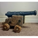 A 17th century Naval cast iron cannon,76cm with wooden trolley base. Cannon has been spiked.