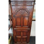 A distressed oak two-door corner cabinet carved panel to front,