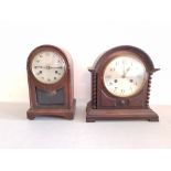 Two oak round-faced mantle clocks.