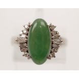A green hardstone and diamond dress ring, set with an oval green hardstone cabochon to centre,