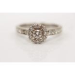 A diamond cluster ring, set with a principal round brilliant cut diamond, measuring approx. 0.