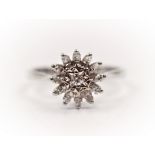 A hallmarked 18ct white gold diamond cluster ring, the two tier design set with a central round