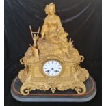 A French gilded clock with figure to top harvest on black wooden base.