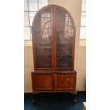 A walnut arched top display cabinet.