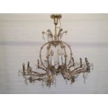 A twelve branch crystal chandelier with droppers and flower design.