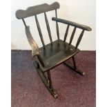 A dark stained primitive style rocking chair.
